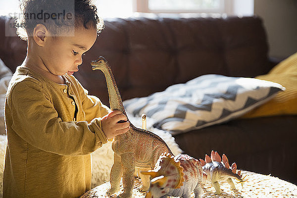 Unschuldiger Junge spielt mit Dinosaurier-Spielzeug