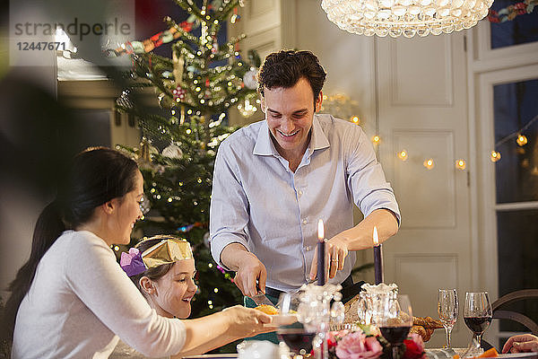 Familie genießt Weihnachtsessen bei Kerzenschein