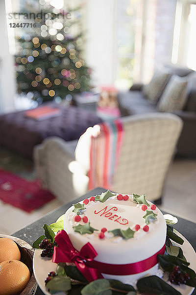 Geschmückter Noel-Weihnachtskuchen auf der Anrichte im Wohnzimmer