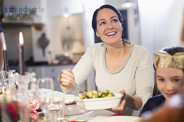 Lächelnde Frau serviert Rosenkohl am Weihnachtstisch