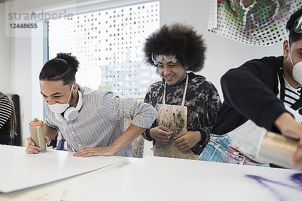 High school boys spray painting in art class