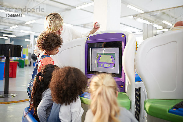 Teacher and students at interactive exhibit in science center