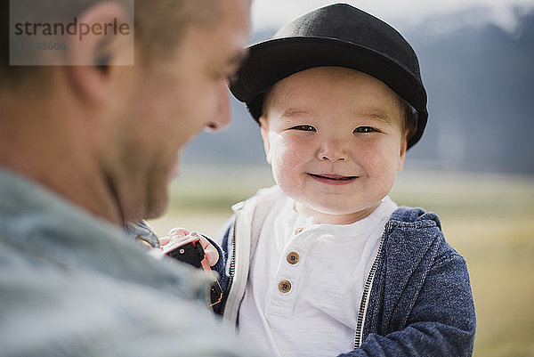 Portrait cute baby boy over father s shoulder