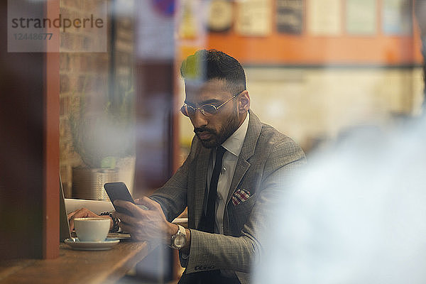 Businessman using smart phone  working in cafe