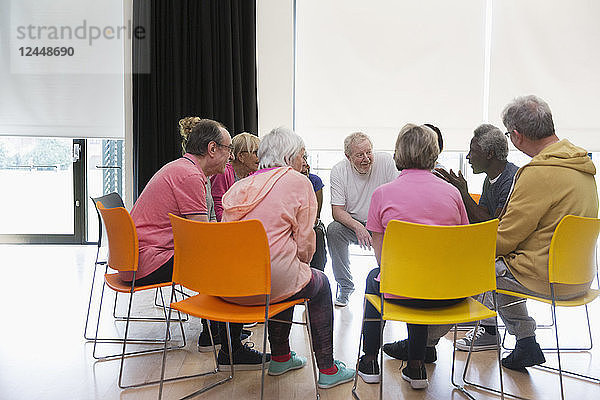 Active seniors talking in circle in community center