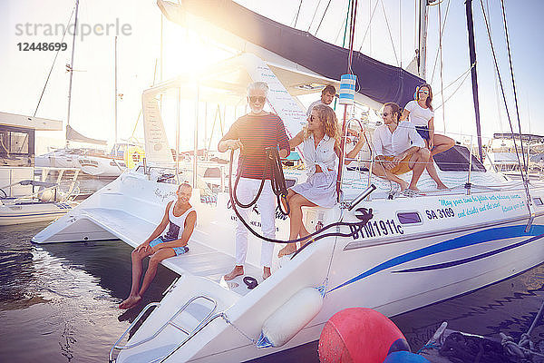 Friends relaxing on catamaran ins sunny harbor