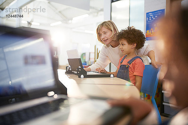 Teacher and schoolgirl using laptop