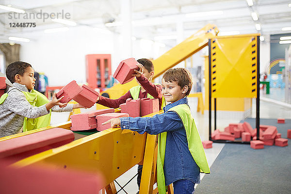 Kids playing with toy bricks at interactive construction exhibit in science center