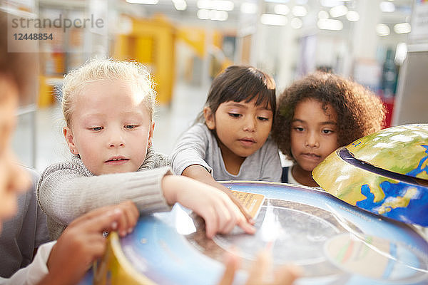 Curious kids at interactive globe exhibit in science center