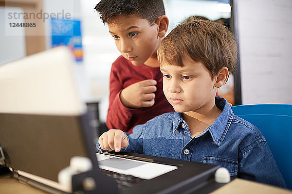 Focused boys using laptop
