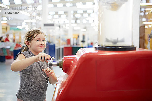 Girl playing with interactive exhibit in science center