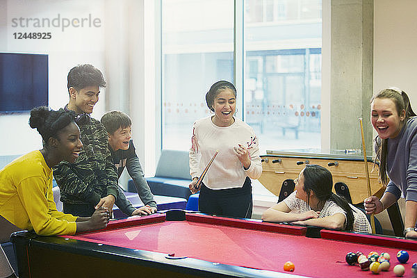 Teenagers playing pool in community center