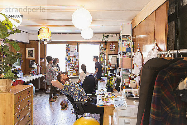 Creative male designer stretching  looking up in office