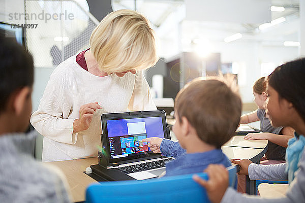 Teacher and students using laptop in science center
