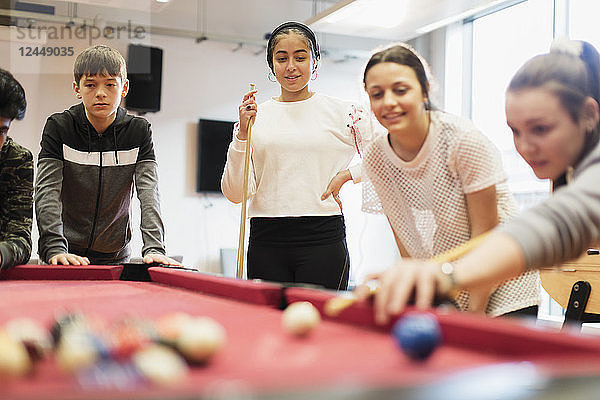 Teenagers playing pool