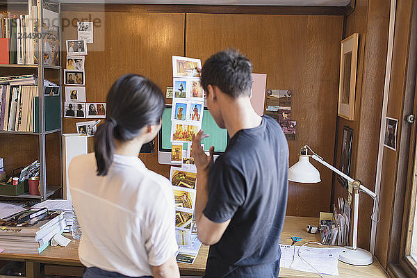Creative designers reviewing photograph proofs in office