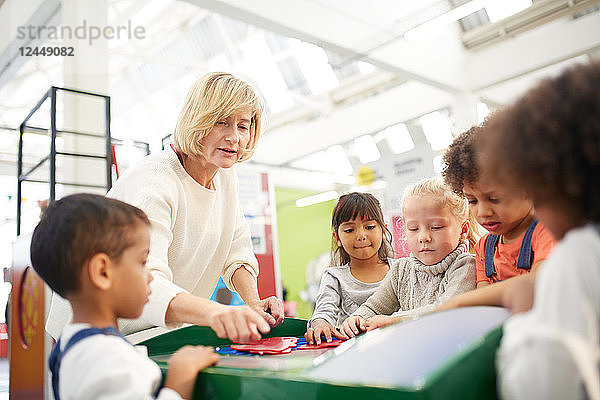 Teacher and students at interactive exhibit in science center