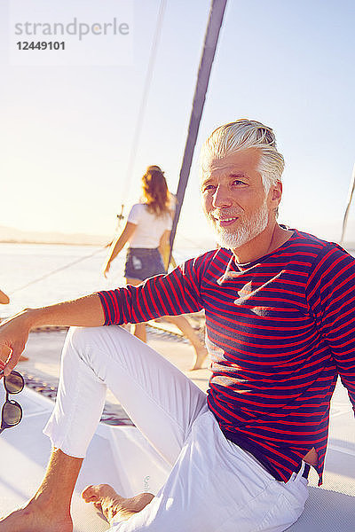 Portrait confident man relaxing on sunny boat