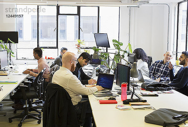 Computer programmers working in open plan office