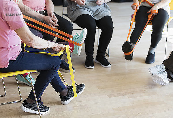 Active seniors stretching  exercising with straps