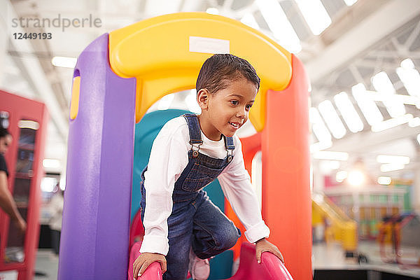 Smiling boy playing on slide