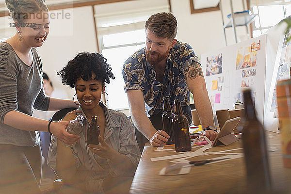 Creative designers examining bottles in office