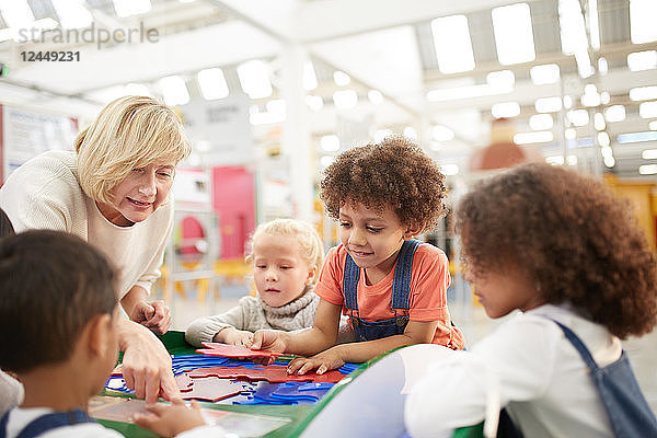 Teacher and students playing at interactive exhibit in science center