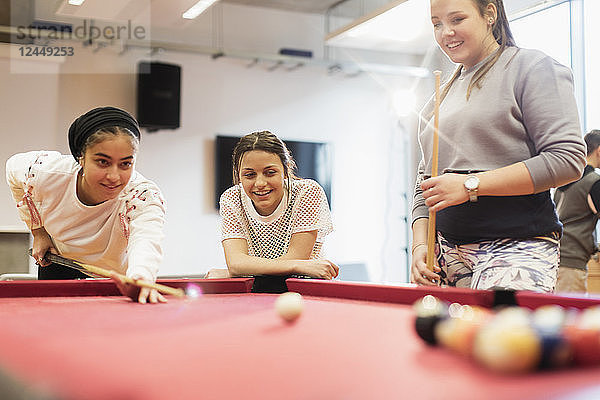 Teenagers playing pool in community center