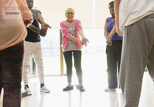 Active seniors stretching wrists in exercise class
