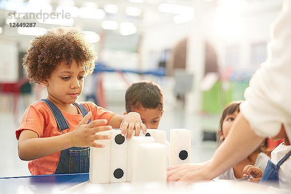 Curious kids playing with large dominos in science center