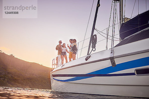 Friends drinking on catamaran at sunset