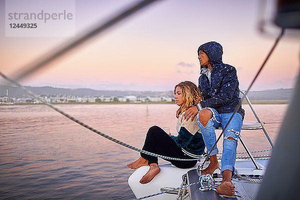 Young couple relaxing on boat at sunset