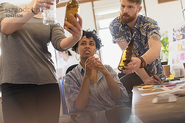 Creative designers examining bottles in office