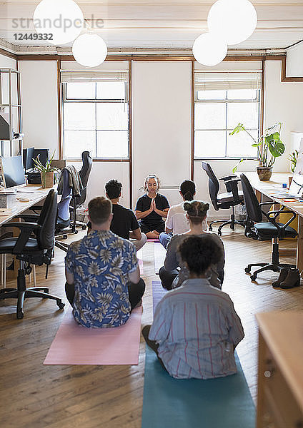 Creative business people meditating in office