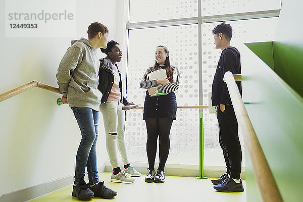 High school students talking on stair landing