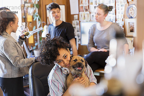 Portrait creative female designer with dog in office