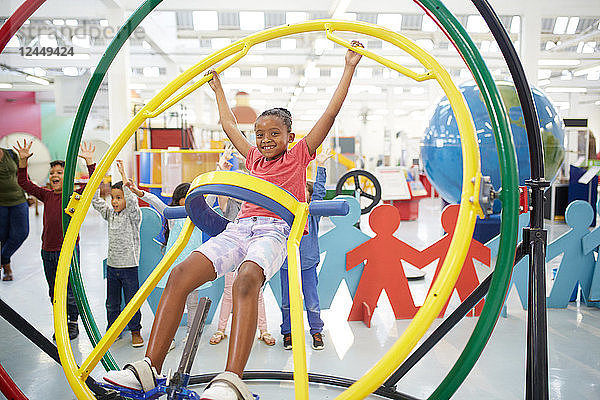 Portrait playful girl using gyroscope in science center