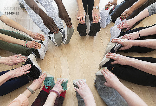 Active seniors stretching legs in circle