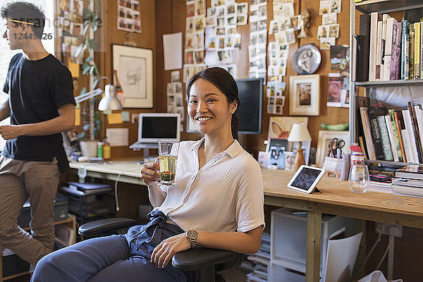Portrait smiling  confident creative businesswoman drinking tea in office