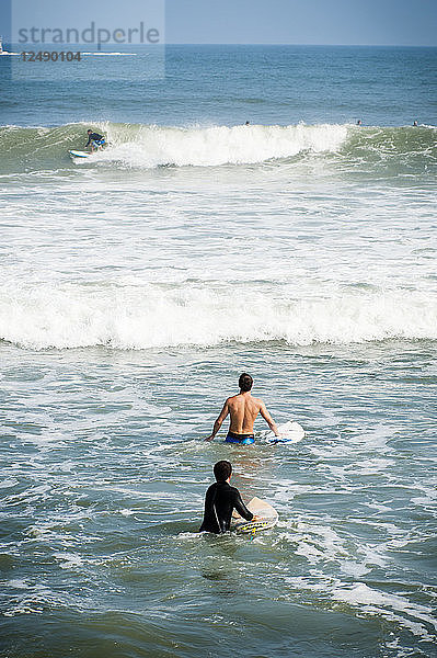 Zwei junge Männer waten durch das Wasser in Point Judith  Rhode Island