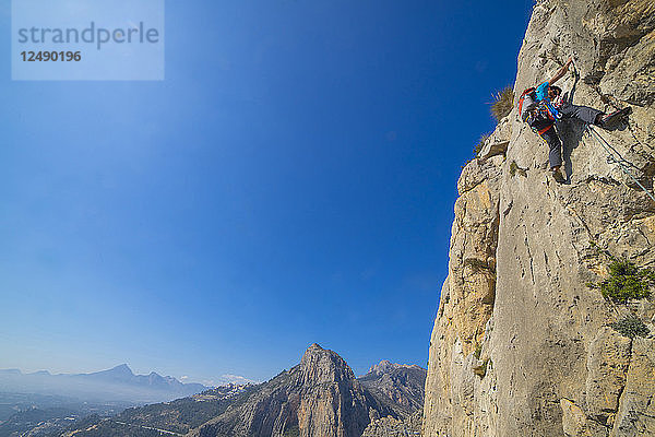 Ein Mann klettert im Vorstieg eine technische Felsroute an der Costa Blanca in Spanien in der Sierra de Toix.