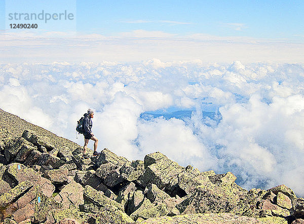 Ein Wanderer steht über den Wolken in der Nähe des Gipfels des Mount Katahdin  Maine.