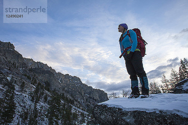 Eine Frau wandert im Morgengrauen zu einem Eisklettersteig im Blodgett Canyon  Bitterroot Mountains  Montana.