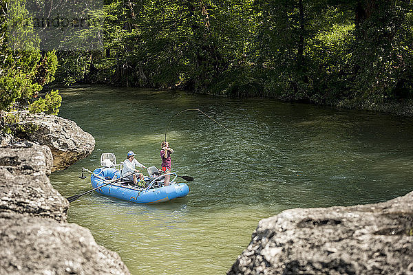 Eine Frau Fliegenfischen für Regenbogenforelle während Mann Reiten Schlauchboot auf Guadalupe River