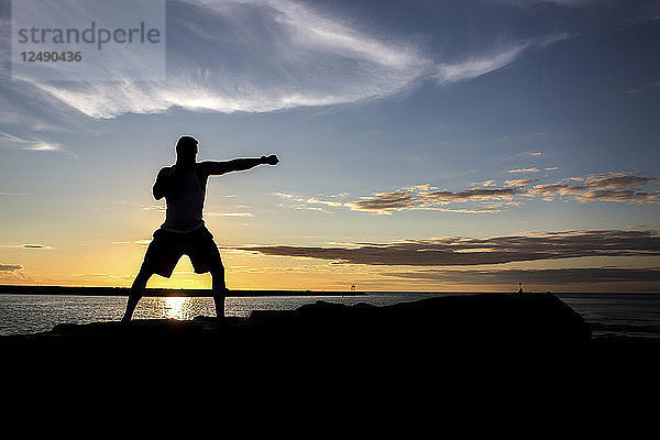 Der Mixed Martial Arts (MMA)-Kämpfer Sean Lally trainiert bei Sonnenuntergang auf einem Steg.