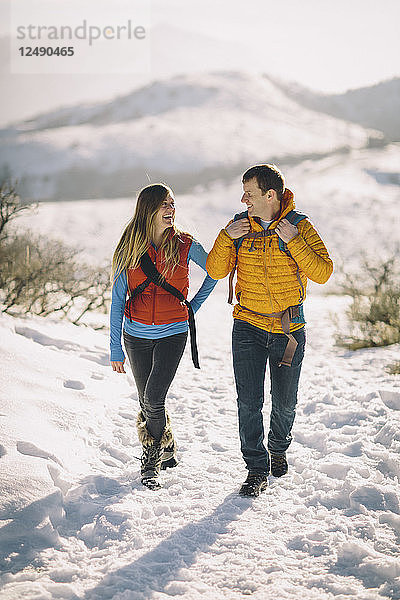 Ein junges Paar wandert in den winterlichen Bergen.