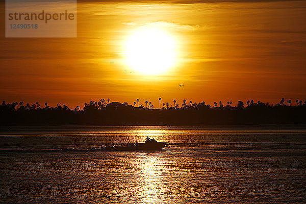 Ein Boot gleitet bei Sonnenuntergang über das Wasser in der Mission Bay in San Diego  Kalifornien.