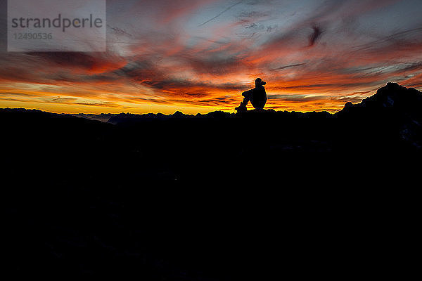 Silhouette eines Wanderers  der den Sonnenuntergang in den französischen Alpen genießt