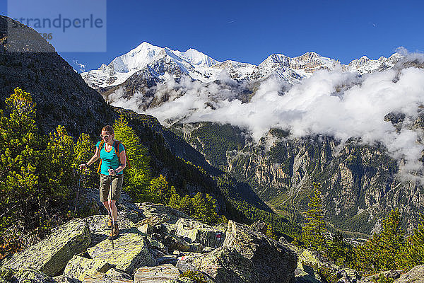 Eine Wanderin auf dem Weg zum Wannihorn  einem Berggipfel in den Schweizer Alpen  in der Nähe von Zermatt. Im Hintergrund ist die Weisshornkette zu sehen. Diese Region im Wallis beherbergt über 40 Viertausender und ist ein Paradies für Outdoor-Fans wie Kletterer  Wanderer  Mountainbiker  Trailrunner und Naturliebhaber.