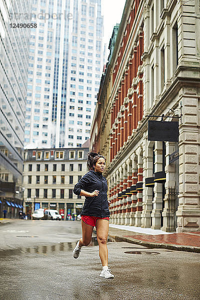 Junge asiatische Mädchen laufen durch die nassen Straßen von Boston